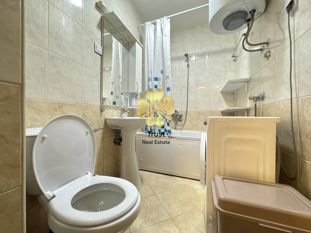 Smaller bathroom with a bathtub, washbasin, toilet, and water heater.