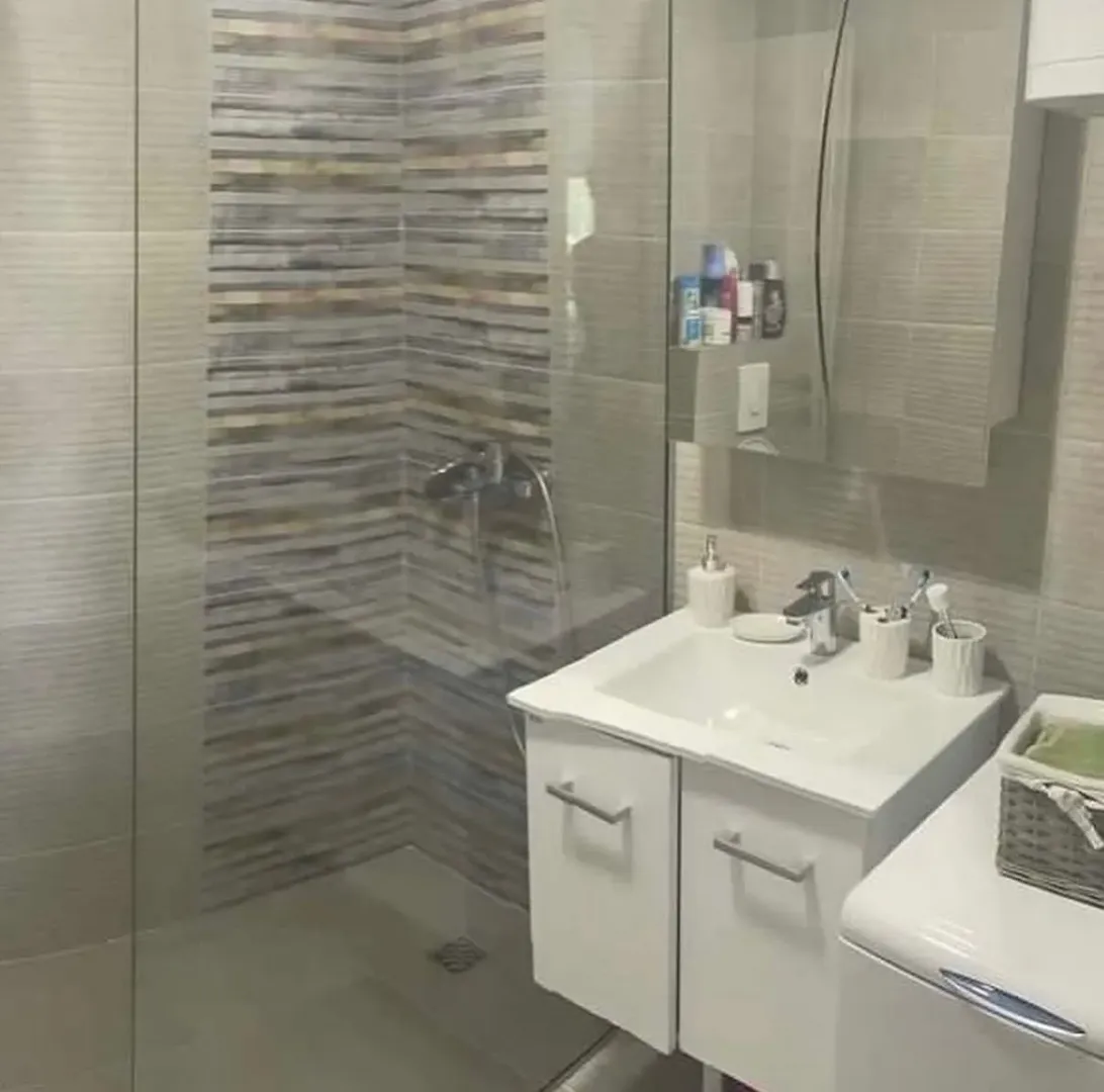 Modern equipped bathroom with a walk-in shower and sink cabinet.