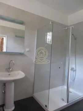 Bathroom with a sink and a glass shower enclosure. - image 4