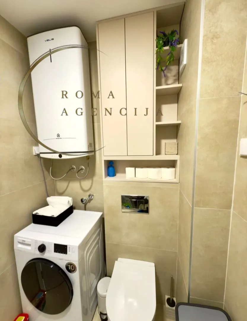 Small bathroom with a washing machine, water heater, and built-in units.