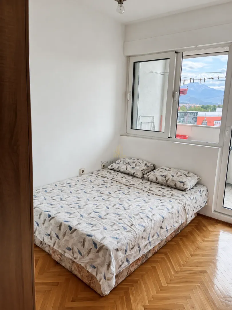 Manja spavaća soba sa bračnim krevetom i izlazom na terasu.
