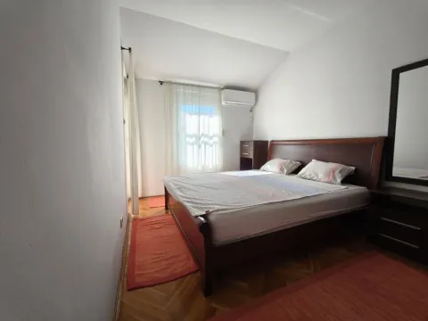 Spavaća soba sa bračnim krevetom i drvenim namještajem. - image 2