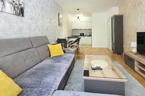 Living room with a sofa and a view towards the dining area and kitchen in the background. - image 4