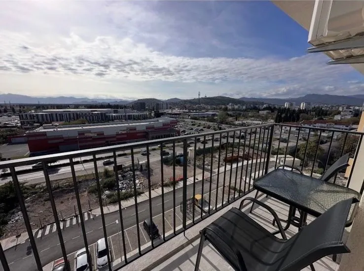 Small furnished balcony with a view of the city and surroundings.