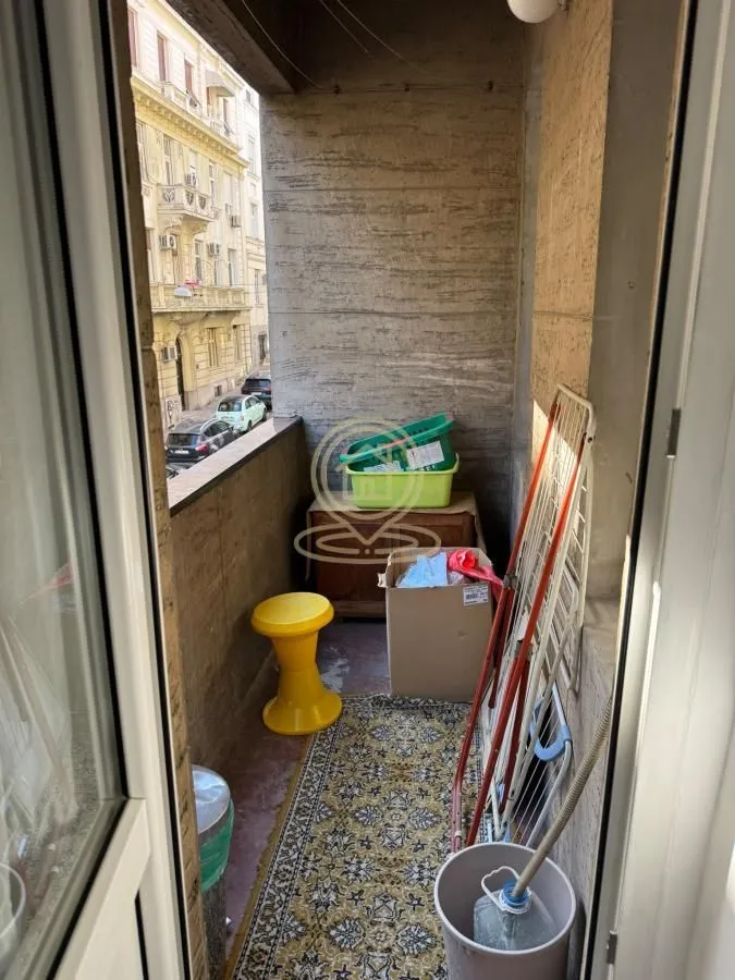 Small balcony with a rug, clothes dryer, and a street view.