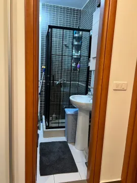 Pogled na kupatilo sa tuš kabinom kroz otvoren vrata. - image 8