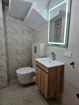 Modern bathroom equipped with a washbasin, toilet, and backlit mirror. - image 6