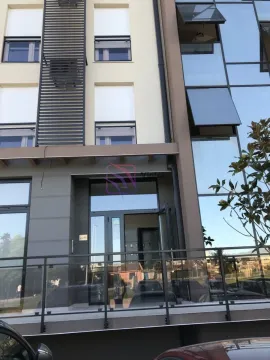 Main entrance and facade of a modern residential building with glass panels. - image 2