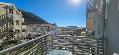View from the balcony overlooking surrounding buildings and the sea. - image 11