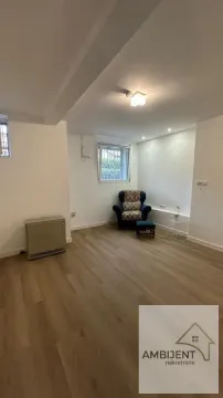 Small bright living room with an armchair and laminate flooring. - image 11