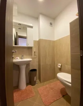 Pogled na kupatilo sa umivaonikom, ogledalom i WC šoljom. - image 9