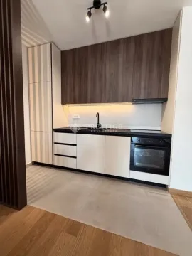 Moderna kuhinja sa bijelim elementima, tamnim gornjim ormarićima i ugrađenom rernom. - image 5
