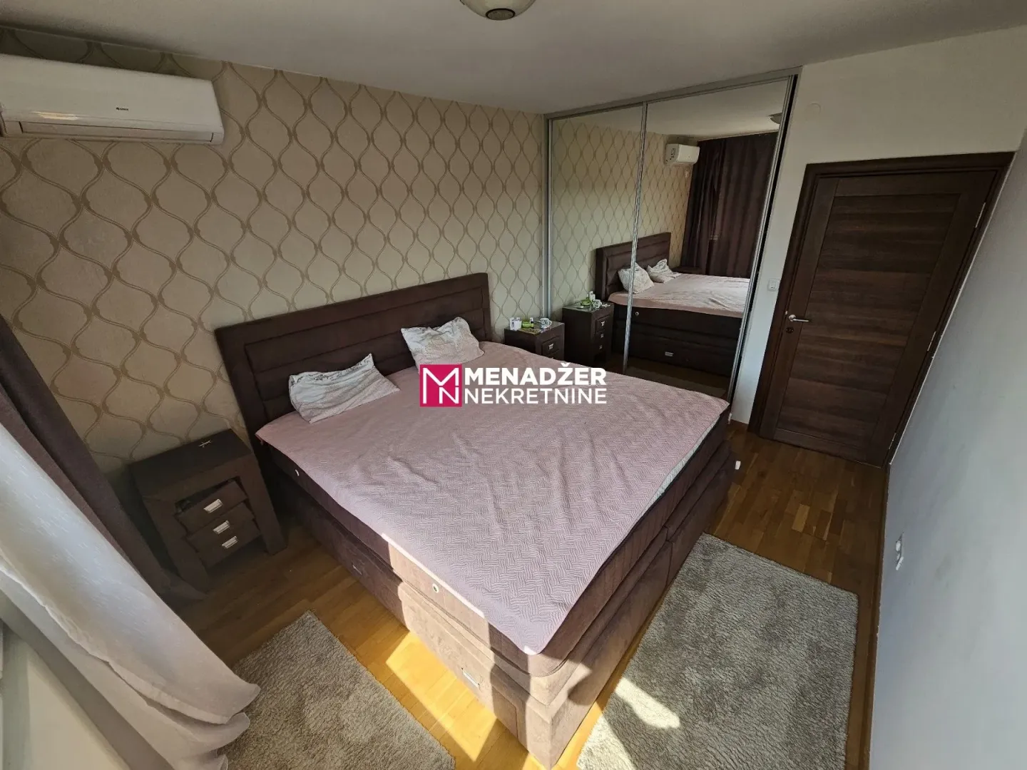 Furnished bedroom with a double bed, wardrobe, and air conditioning.