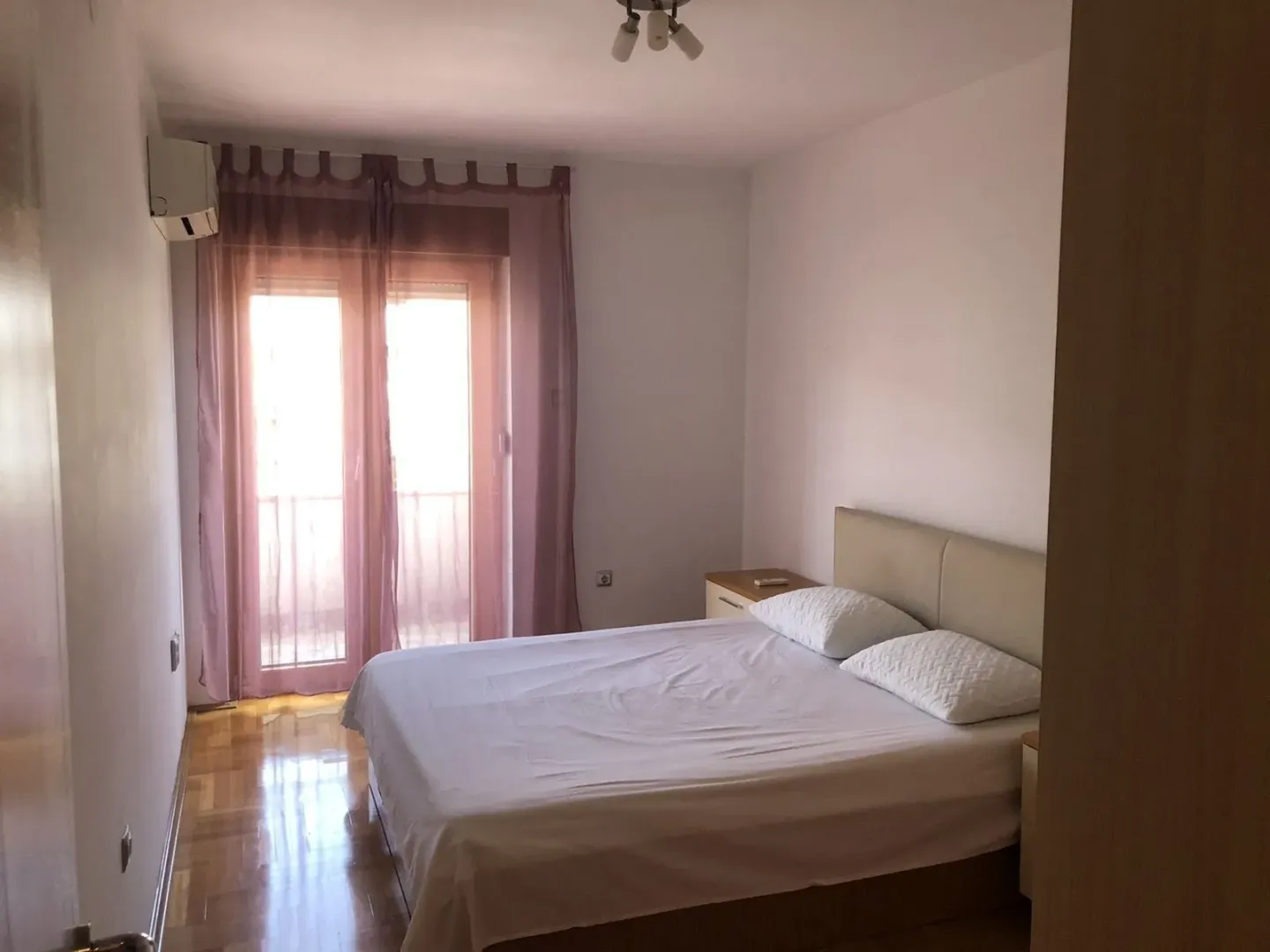 Bedroom with a double bed and balcony doors.