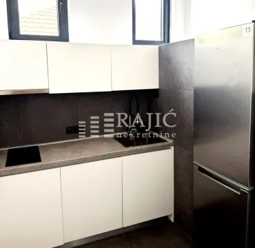 Modern kitchen with white cabinets and gray countertops. - image 4