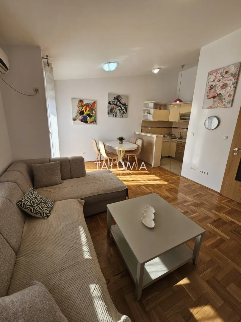 Living room with a sofa set and a dining area in the background.