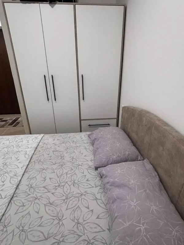 Spavaća soba sa bračnim krevetom i ugradnim ormarom.