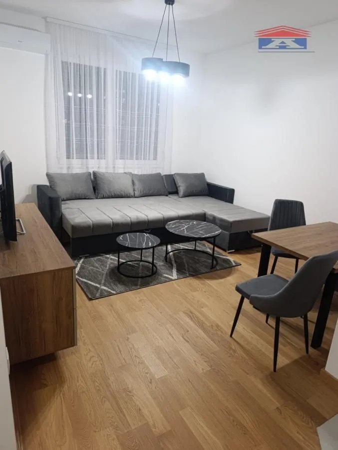 Dnevna soba sa ugaonom garniturom, stočićima i trpezarijskim delom.