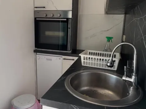 View of a kitchen area with a sink, oven, and countertop. - image 11