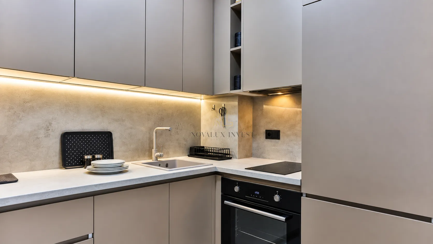 Modern kitchen with built-in oven, hob, and sink.