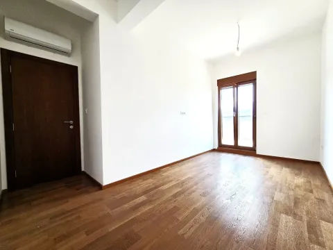Empty room with wooden flooring and balcony doors. - image 23