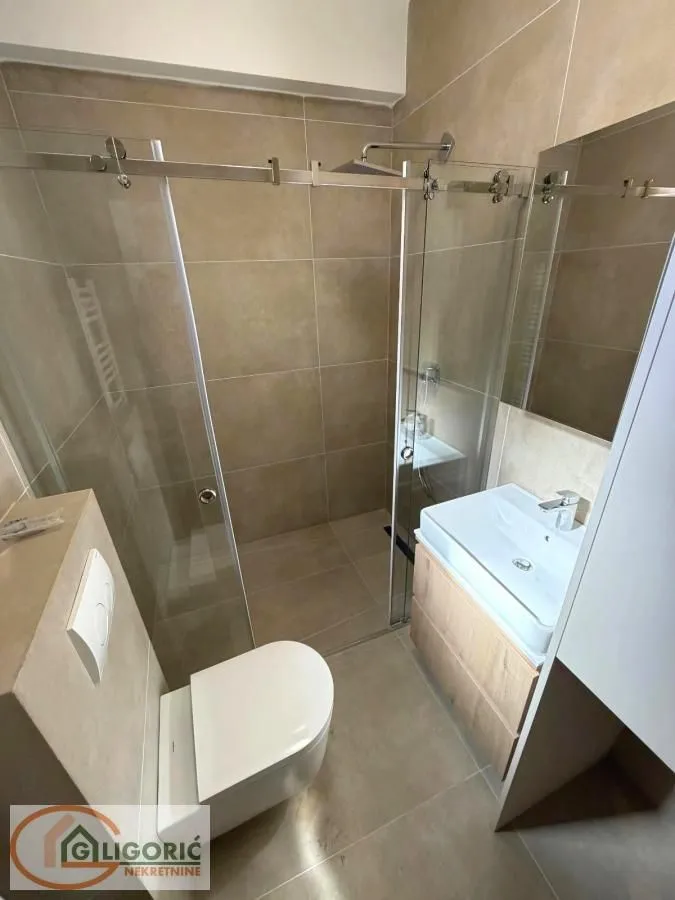 Modernly equipped bathroom with a shower cabin and a sink.