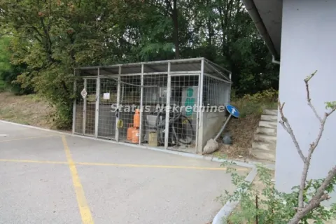 Exterior part of the building with a fenced storage area and parking space in the background. - image 18