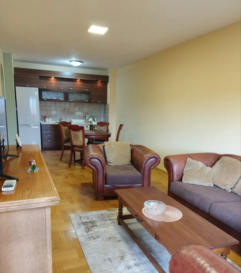 Living room with leather furniture and kitchen.