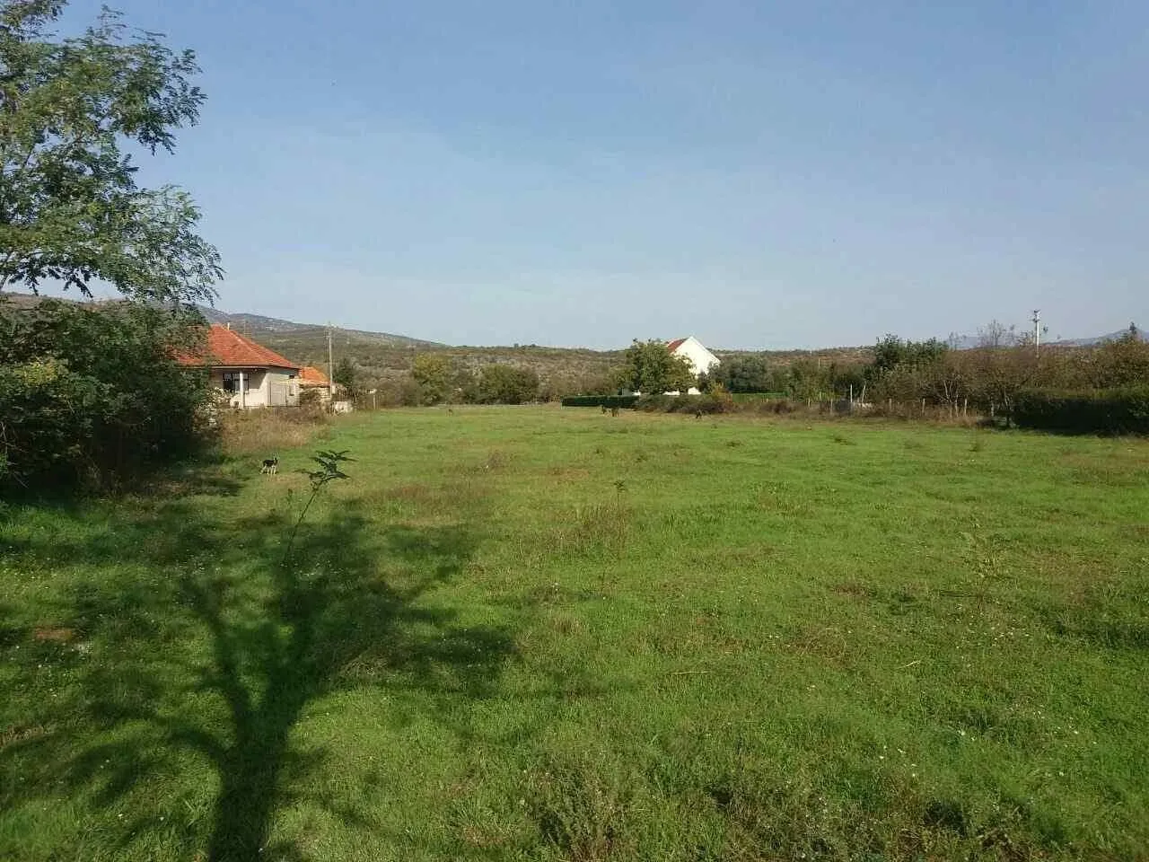 Zeleni plac u mirnom okruženju sa pogledom na prirodu.