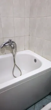 Bijela kada sa slavinom i keramičkim pločicama na zidu. - image 7