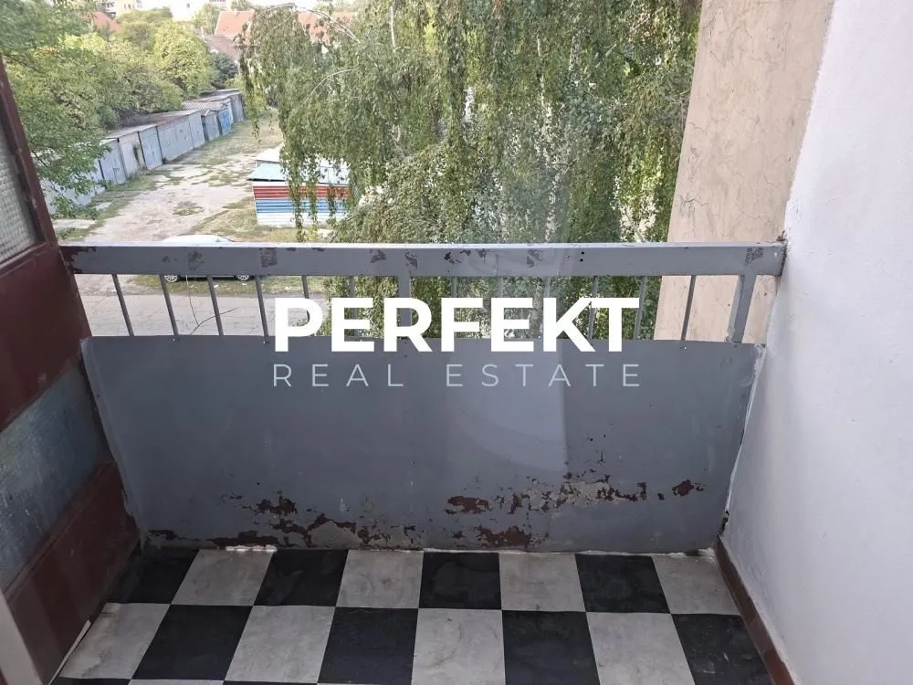 Pogled sa balkona na zelene površine i dvorište.