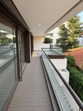Prostrani popločani balkon sa staklenom ogradom i pogledom na okolinu. - image 10