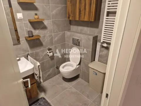 Modernly equipped bathroom with grey tiles and wooden details. - image 12