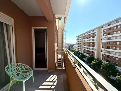 Spacious balcony with a chair and a view of buildings. - image 5