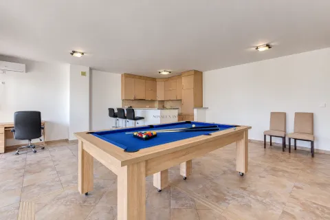Spacious living room with a pool table and kitchen in the background. - image 2