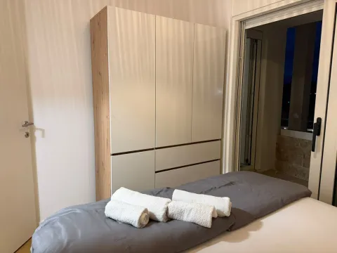 Spavaća soba sa velikim garderoberom i krevetom sa složenim peškirima. - image 8