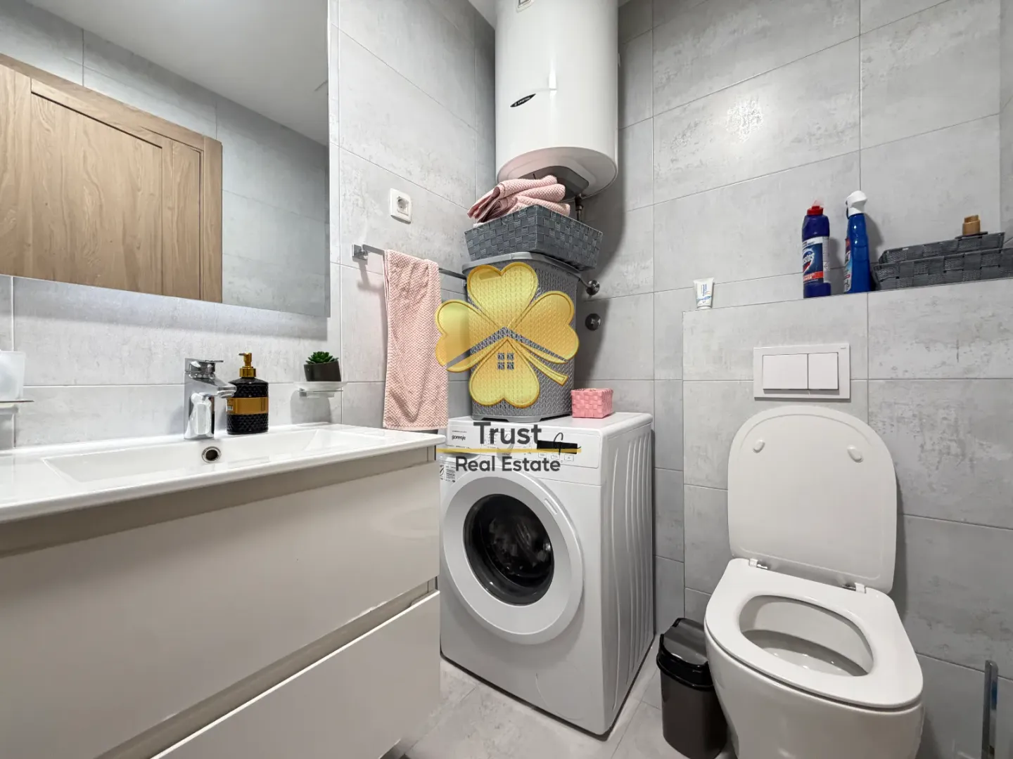 Moderne kupatilo sa umivaonikom, veš mašinom i toaletom.