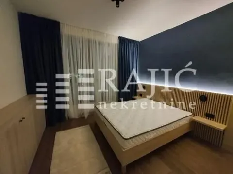 Modern bedroom with a double bed and a wooden wall panel. - image 9