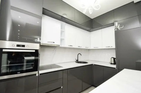 Modern kitchen with dark and white cabinets and built-in appliances. - image 4