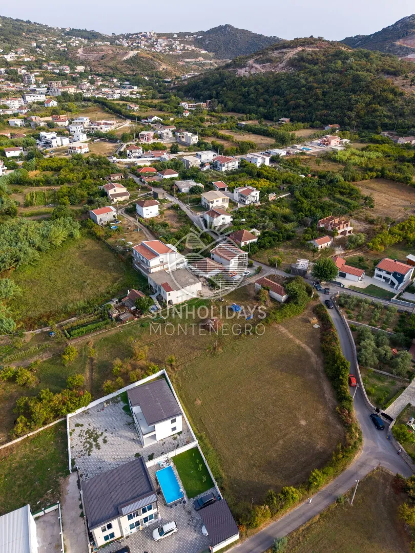 Pogled iz vazduha na naselje i okolnu prirodu.
