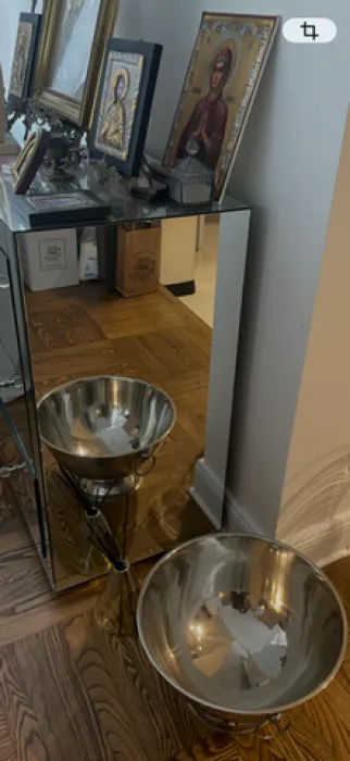 Detalj enterijera sa ogledalom i dekorativnim predmetima.