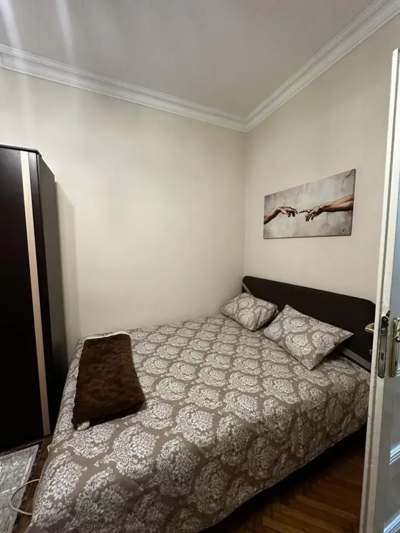 Small bedroom with a double bed, wardrobe, and a wall painting.