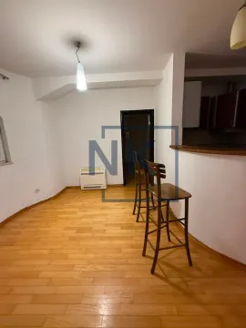 Living room with wooden flooring and a breakfast bar leading to the kitchen. - image 2