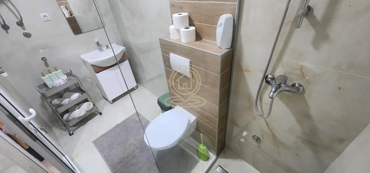 Savremeno opremljeno kupatilo sa tuš kabinom, umivaonikom i WC šoljom.