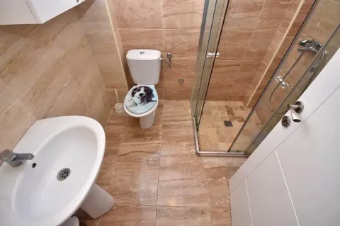 Kompaktno kupatilo obloženo keramičkim pločicama sa tuš kabinom. - image 9