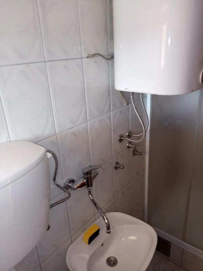 Part of a bathroom with a sink and a water heater.