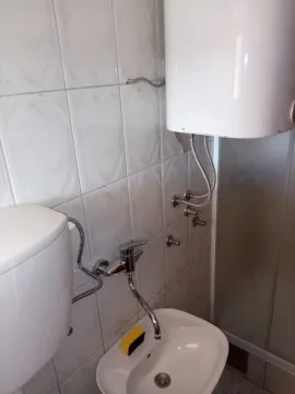 Part of a bathroom with a sink and a water heater. - image 16