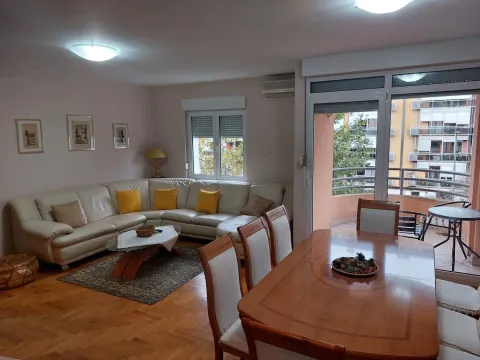 Bright living room featuring a large corner sofa and a dining table. - image 2