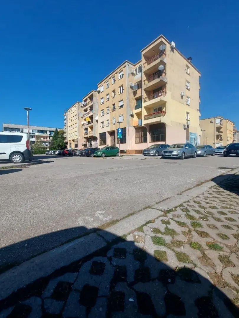 Exterior view of an apartment building with parking in front.