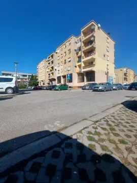 Exterior view of an apartment building with parking in front. - image 5